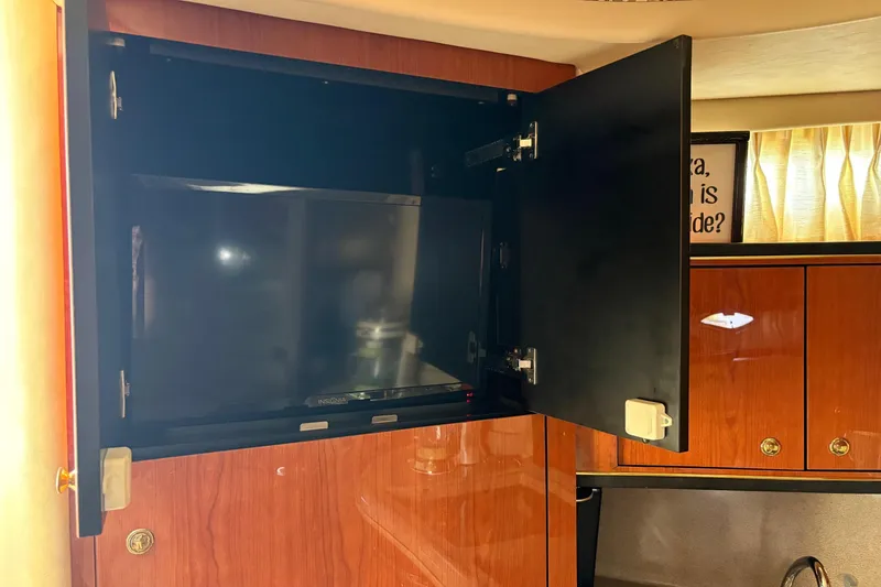 Slide: The Image of 2001 Sea Ray 460 Sundancer interior with open cabinet and TV. - 56