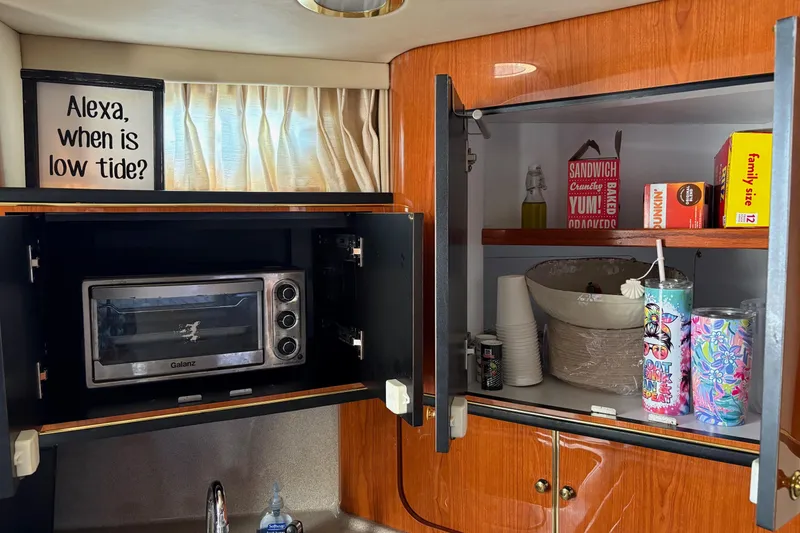 Slide: The Image of 2001 Sea Ray 460 Sundancer kitchen with toaster oven, snacks, and humorous sign. - 58