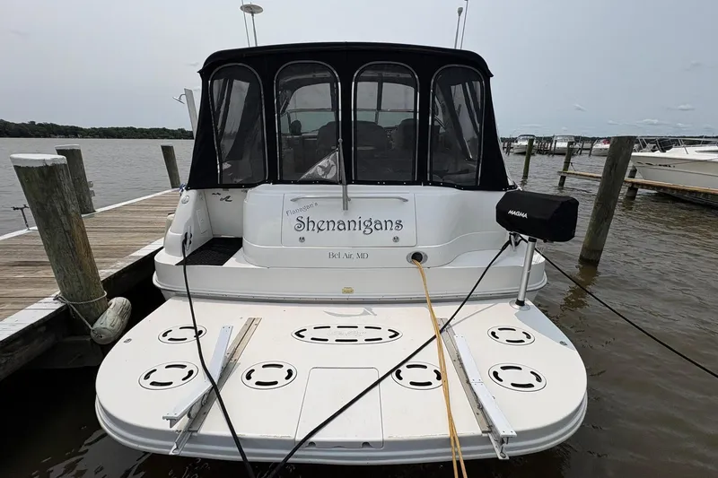 Slide: The Image of 2001 Sea Ray 460 Sundancer docked, rear view with "Shenanigans" name visible. - 7