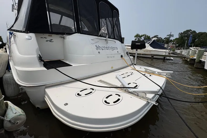 Slide: The Image of 2001 Sea Ray 460 Sundancer docked, rear view with swim platform and marina background. - 8