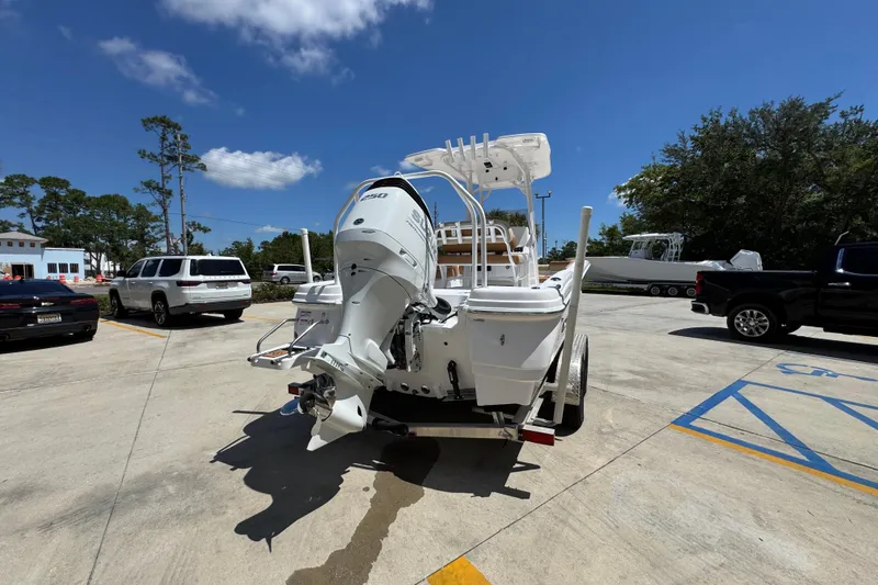 Slide: The Image of 2026 NauticStar 231 Hybrid boat on trailer in sunny parking lot. - 12