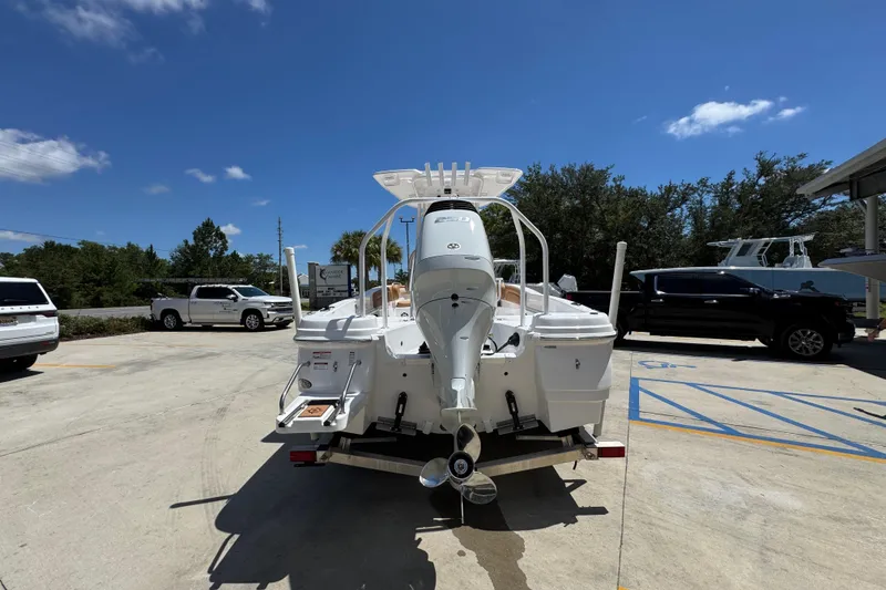 Slide: The Image of 2026 NauticStar 231 Hybrid boat on trailer, parked outdoors under clear blue sky. - 13