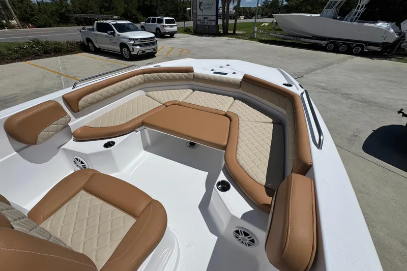 Slide: The Image of 2026 NauticStar 231 Hybrid boat with tan and beige seating in a parking lot. - 17