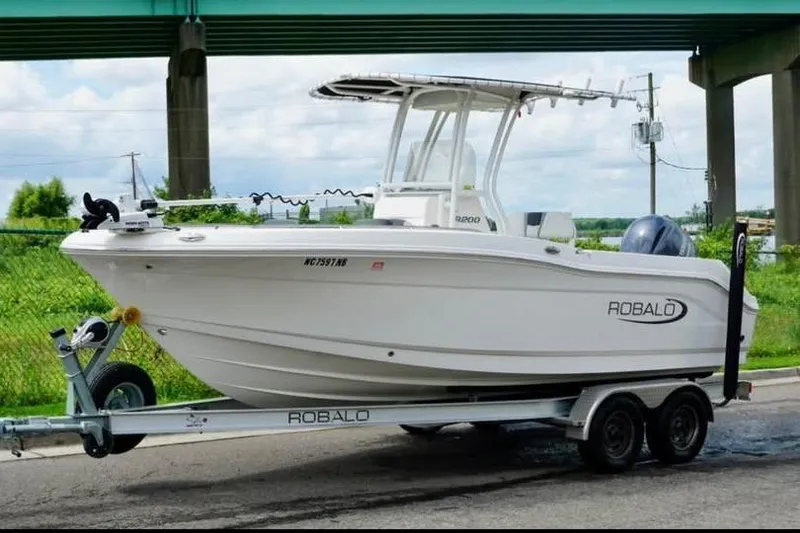 Slide: The Image of 2023 Robalo R200 Center Console boat on trailer under bridge. - 17