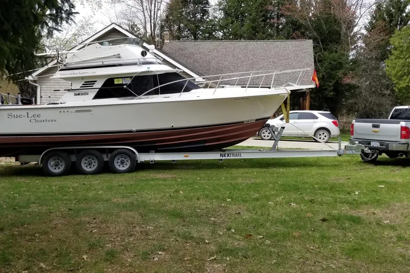 Slide: The Image of 1990 Blackfin 29 Sportfish boat on trailer, parked in residential yard. - 2