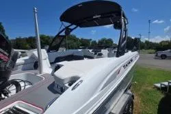 Slide: The Image of 2021 Tahoe 210 S Limited boat with sleek design, parked outdoors under clear blue sky. - 11