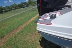 Slide: The Image of 2021 Tahoe 210 S Limited boat on grass, open storage compartment, sunny day. - 12