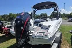 Slide: The Image of 2021 Tahoe 210 S Limited boat on trailer, featuring outboard motor, parked outdoors. - 4