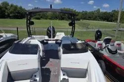 Slide: The Image of 2021 Tahoe 210 S Limited boat with sleek design, parked outdoors under a clear sky. - 9