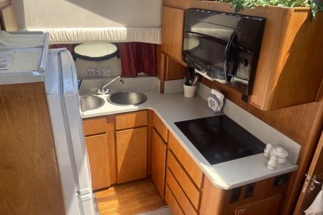 Slide: The Image of Compact kitchen in a 1990 Carver 55 yacht with wooden cabinets and modern appliances. - 18