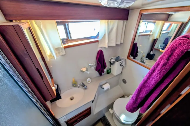 Slide: The Image of Bathroom interior of a 1990 Carver 55 yacht, featuring sink, toilet, and mirror. - 23
