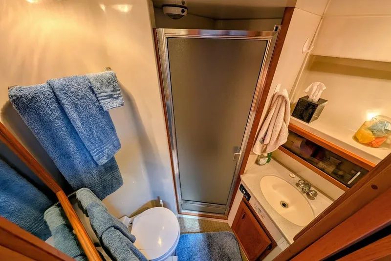 Slide: The Image of Compact bathroom in 1990 Carver 55 yacht with shower, sink, and blue towels. - 26