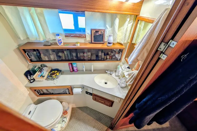 Slide: The Image of Bathroom interior of a 1990 Carver 55 yacht, featuring sink, toiletries, and storage. - 27