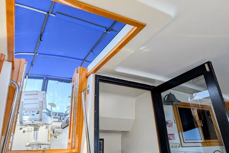 Slide: The Image of Interior view of 1990 Carver 55 yacht with blue canopy and helm station. - 37