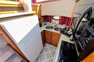 Slide: The Image of Compact kitchen in a 1990 Carver 55 yacht with modern appliances and dual sinks. - 19