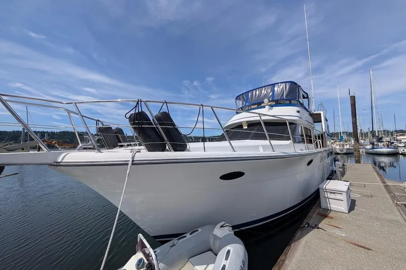 Slide: The Image of 1990 Carver 55 yacht docked at marina under clear blue sky. - 2