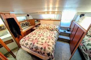 Slide: The Image of Cozy bedroom interior of 1990 Carver 55 yacht with quilted bedspread and wooden cabinetry. - 29