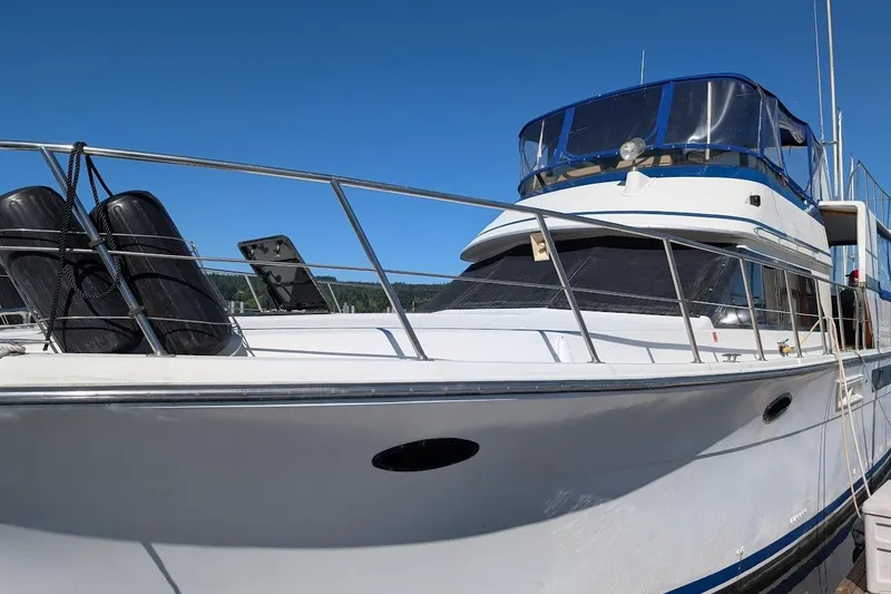 Slide: The Image of 1990 Carver 55 yacht docked under clear blue sky. - 3