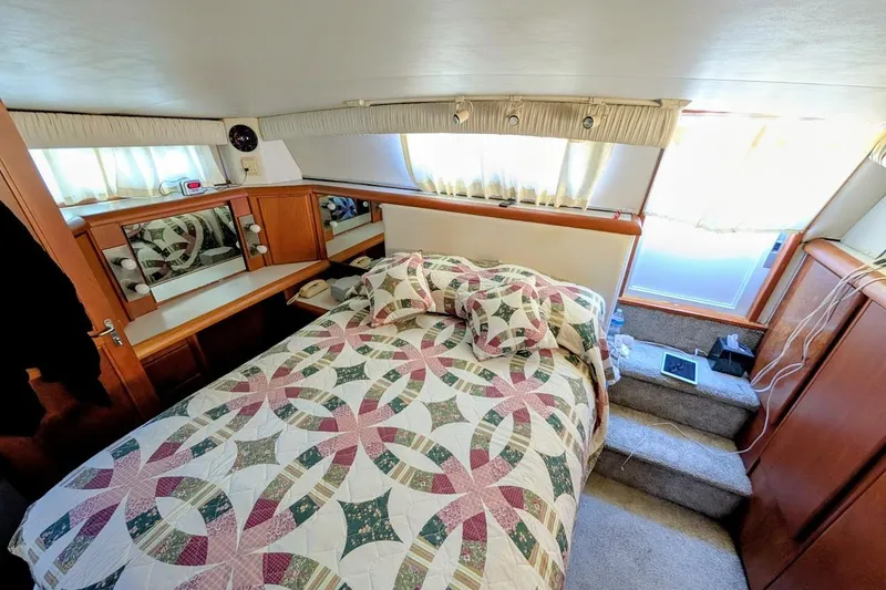 Slide: The Image of Cozy bedroom interior of 1990 Carver 55 yacht with quilted bedding and wooden cabinetry. - 30