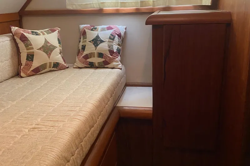 Slide: The Image of Cozy cabin interior of 1990 Carver 55 with patterned pillows and wooden cabinetry. - 32