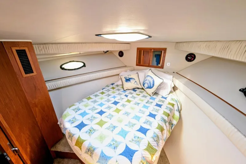 Slide: The Image of Cozy bedroom in 1990 Carver 55 yacht with nautical-themed bedding and wooden accents. - 33