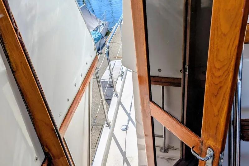 Slide: The Image of 1990 Carver 55 yacht deck with wooden railings and white panels. - 38