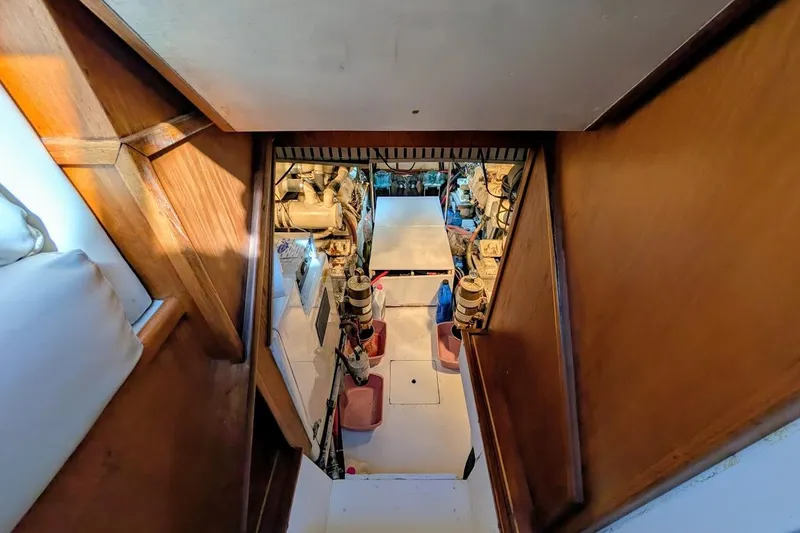 Slide: The Image of Engine room of a 1990 Carver 55 yacht, featuring mechanical components and wooden interior. - 39