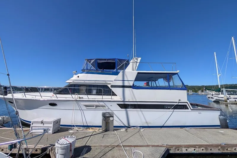 Slide: The Image of 1990 Carver 55 yacht docked at marina under clear blue sky. - 6