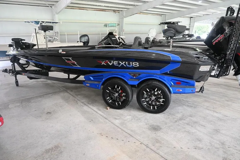 The Image of 2026 Vexus VX s21 boat with blue accents on a trailer in a covered area. - 0
