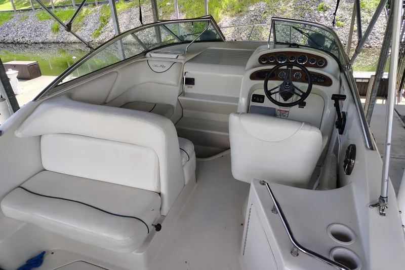 Slide: The Image of Interior of 2000 Sea Ray 240 Sundancer boat with white seating and steering console. - 1