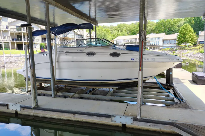 Slide: The Image of 2000 Sea Ray 240 Sundancer boat docked in a marina with covered shelter. - 10