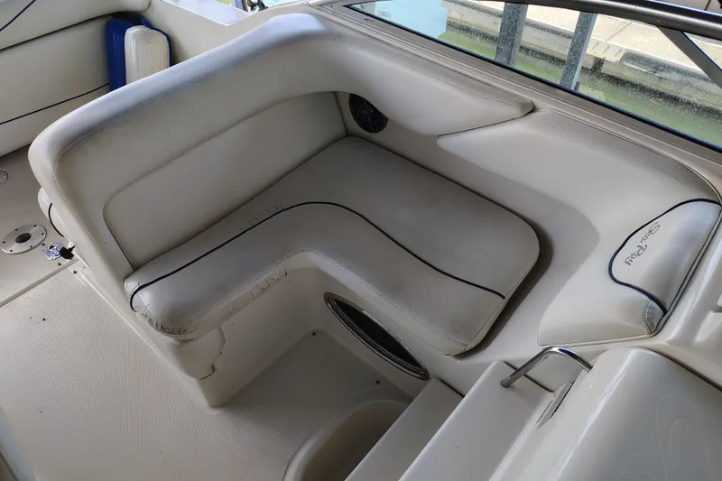 Slide: The Image of 2000 Sea Ray 240 Sundancer boat interior seating with white upholstery and blue accents. - 17
