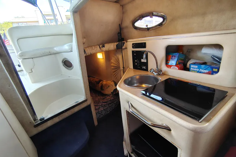 Slide: The Image of Interior of 2000 Sea Ray 240 Sundancer with kitchenette, sink, and storage space. - 18