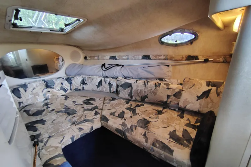 Slide: The Image of Interior of 2000 Sea Ray 240 Sundancer with patterned seating and porthole windows. - 21