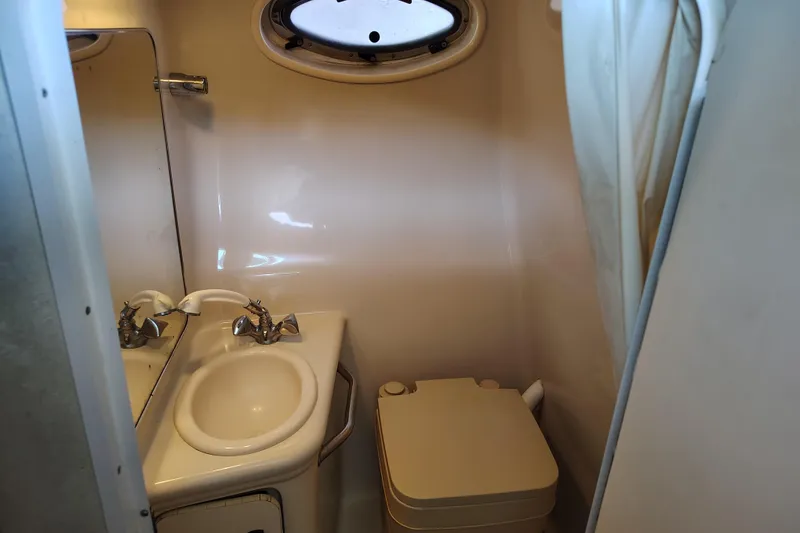 Slide: The Image of Compact bathroom in 2000 Sea Ray 240 Sundancer boat with sink and toilet. - 22