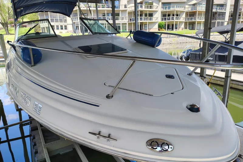 Slide: The Image of 2000 Sea Ray 240 Sundancer docked, featuring sleek design and spacious deck. - 5
