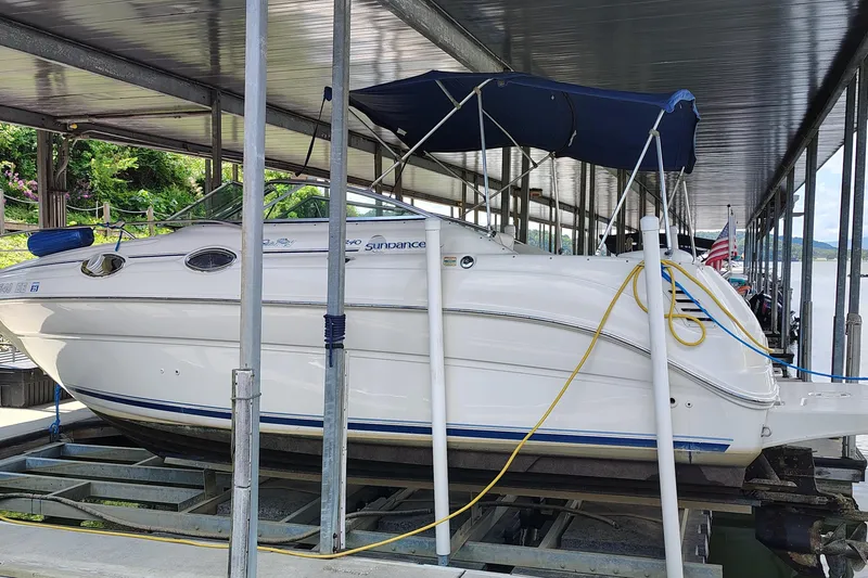 Slide: The Image of 2000 Sea Ray 240 Sundancer boat docked under a covered marina. - 7
