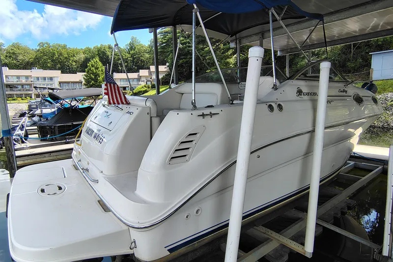 Slide: The Image of 2000 Sea Ray 240 Sundancer boat docked under a canopy with American flag. - 9