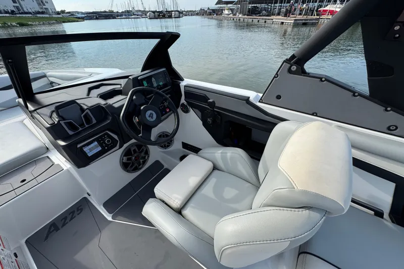 Slide: The Image of 2023 Axis A225 boat interior with steering wheel and comfortable seating by the water. - 12