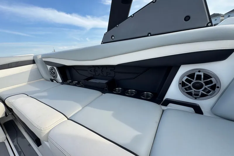Slide: The Image of 2023 Axis A225 boat interior with speakers and cup holders, featuring sleek seating design. - 21