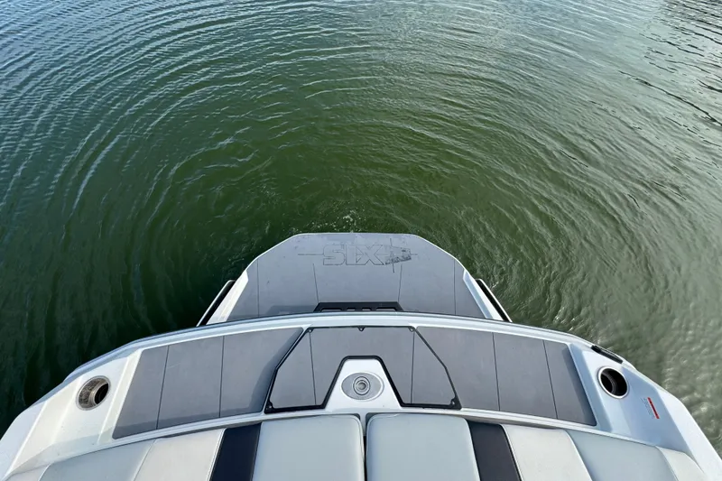 Slide: The Image of 2023 Axis A225 boat stern on calm water, showcasing sleek design. - 25