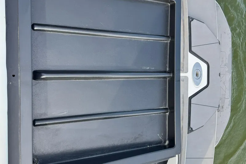 Slide: The Image of 2023 Axis A225 boat platform with sleek black and gray design on water. - 27