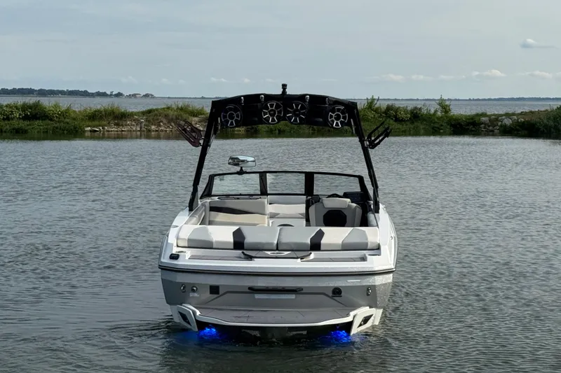 Slide: The Image of 2023 Axis A225 boat with speakers, illuminated in water, scenic lake background. - 6