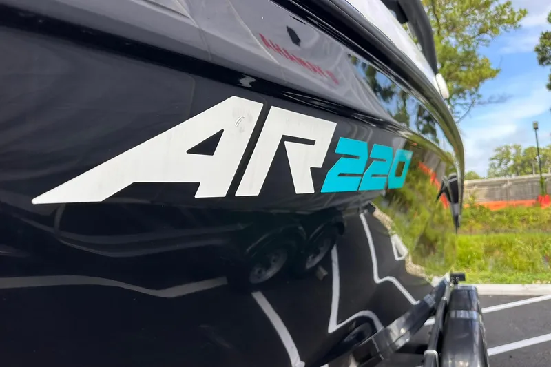 Slide: The Image of 2025 Yamaha Boats AR220 logo on sleek black hull, outdoor setting. - 2