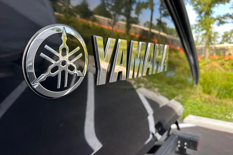 Slide: The Image of 2025 Yamaha AR220 boat logo on sleek black surface, outdoor setting. - 4