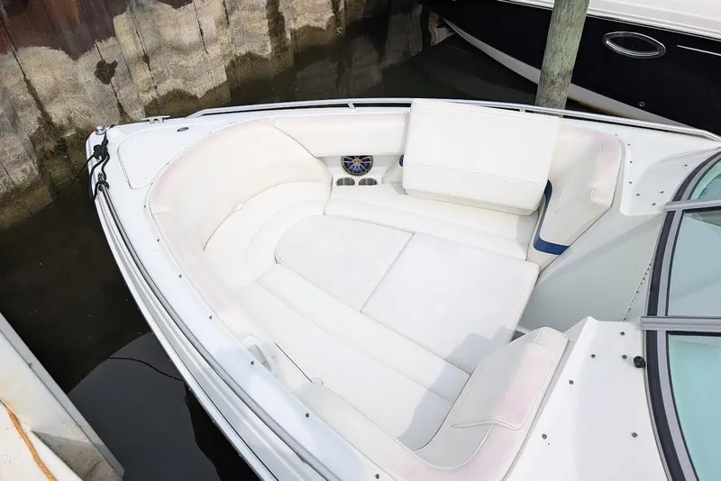 Slide: The Image of 2005 Formula 260 Bowrider boat with white seating, docked in water. - 12