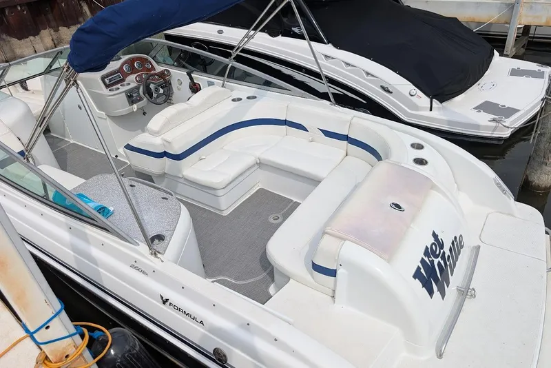 Slide: The Image of 2005 Formula 260 Bowrider boat with white seating and blue accents docked at marina. - 14