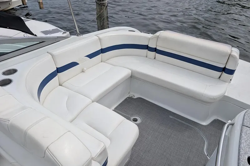 Slide: The Image of 2005 Formula 260 Bowrider boat interior with white and blue seating, docked by water. - 18