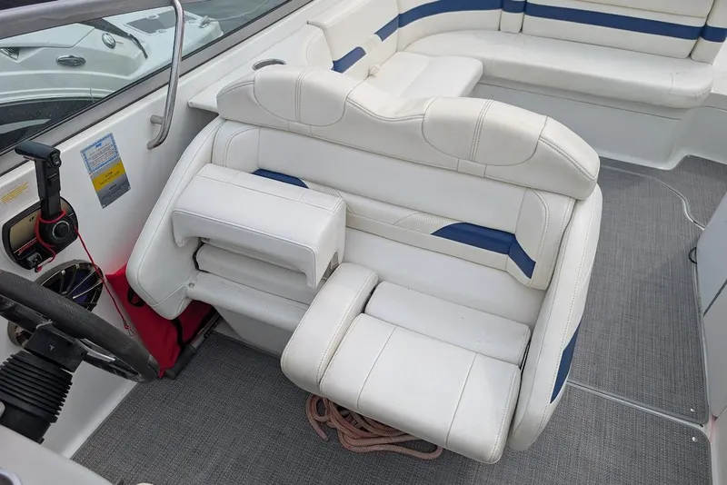 Slide: The Image of 2005 Formula 260 Bowrider interior with white and blue seating, steering wheel, and controls. - 23
