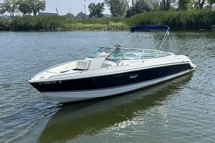 Slide: The Image of 2005 Formula 260 Bowrider boat on calm water with lush greenery in the background. - 7